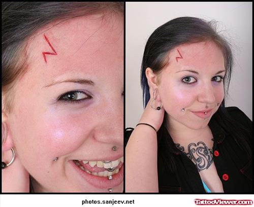 Red Ink Geek Tattoo On Forehead