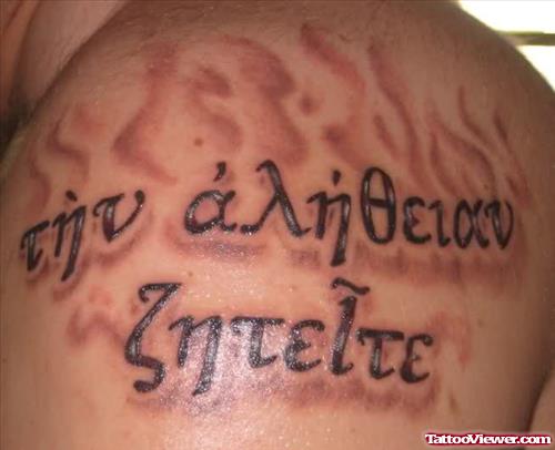 Grey Ink Flaming Greek Tattoo On Left Shoulder