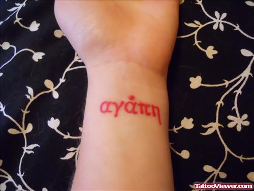 Red Ink Greek Lettering Tattoo On Wrist