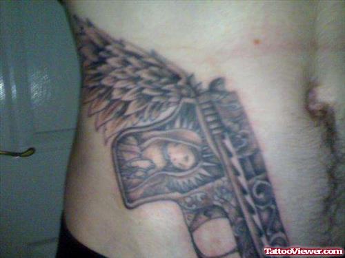 Grey Ink Winged Pistol Tattoo On Man Side Rib