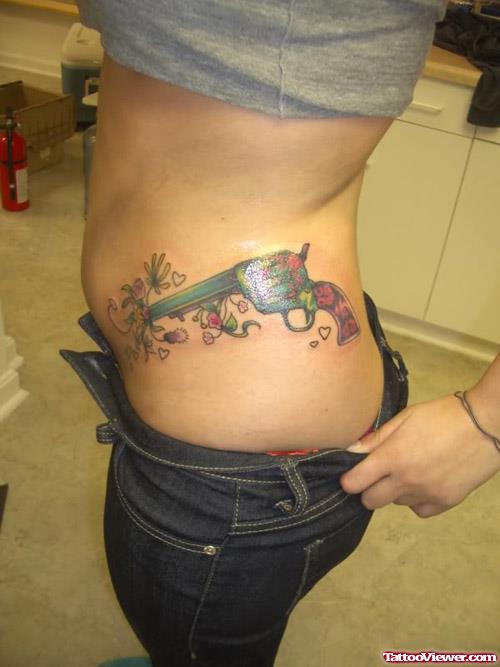 Colored Gun Tattoo On Girl Rib Side
