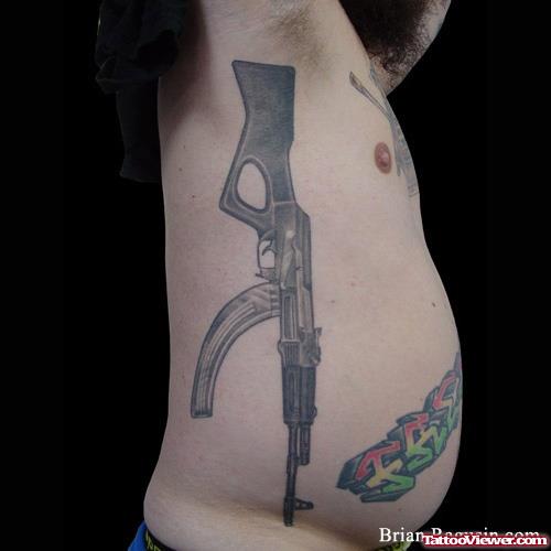 Amazing Grey Ink Gun Tattoo On Man Rib Side