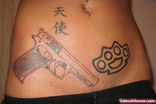 Knuckles And Gun Tattoo On Hip