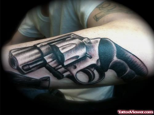 Grey Ink Gun Tattoo On Left Arm