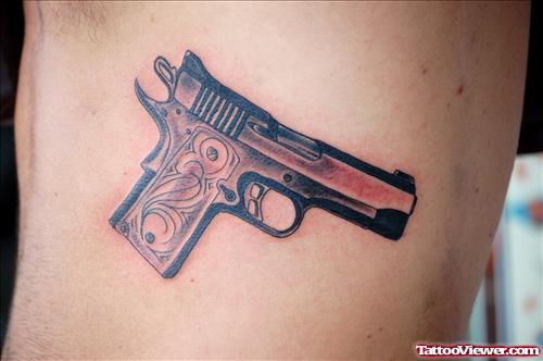 Brown Ink Gun Tattoo On Side Rib