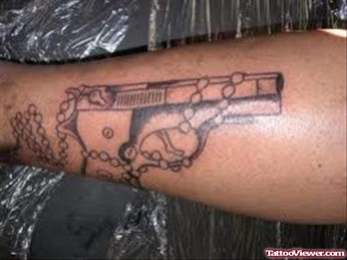 Rosary And Gun Tattoo On Arm