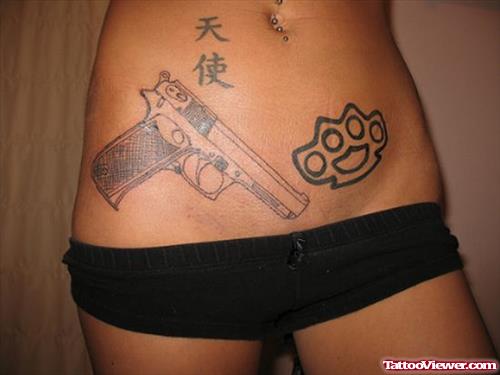 Knuckles And Gun Tattoo On Hips