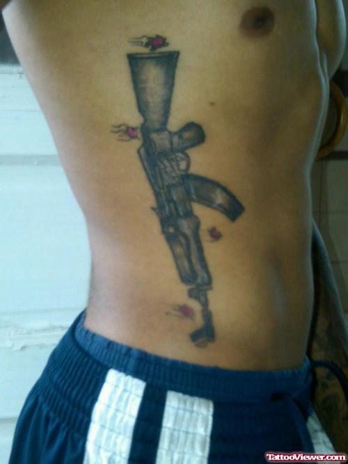 Grey Ink Gun Tattoo On Man Rib Side