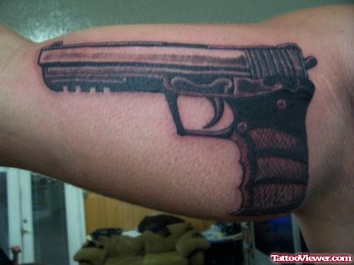 Beautiful Grey Ink Gun Tattoo On Muscles
