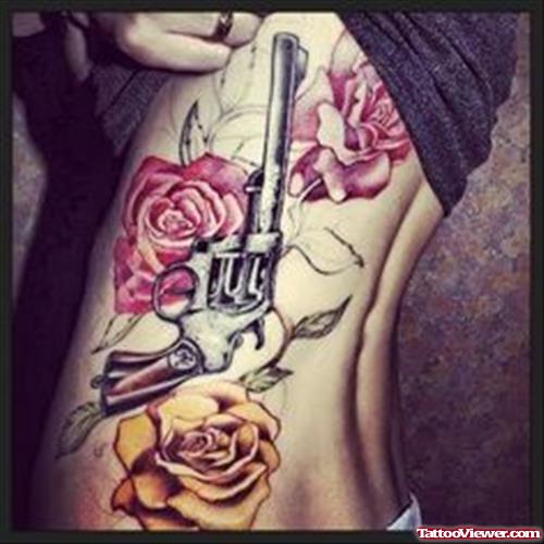 Red Rose Flowers And Gun Tattoo On Side Rib