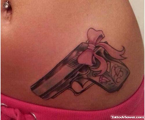 Gun with Pink Bow Tattoo On Left Hip