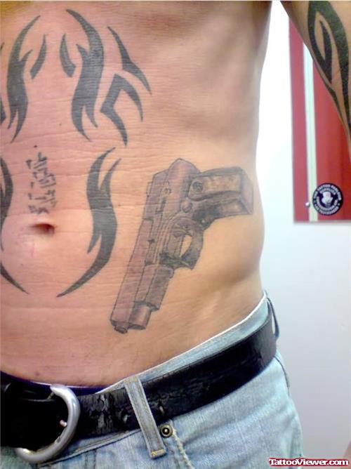 Tribal and Gun Tattoo On Side