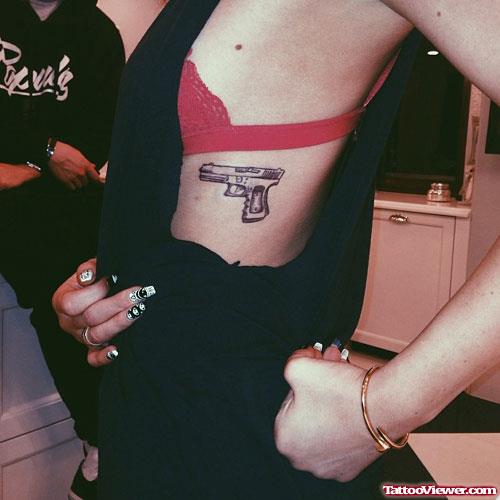 Small Gun Tattoo On Girl Rib Side
