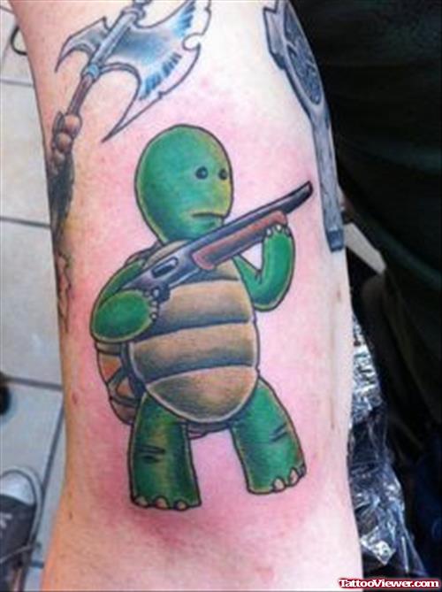 Green Ink Turtle With Gun Tattoo On Bicep