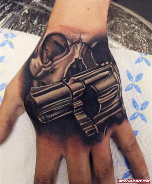 Skull And Gun Tattoo On Left Hand