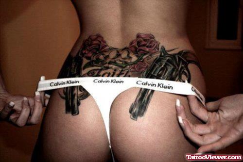 Red Rose Flowers And Guns Tattoos On Girl Lowerback