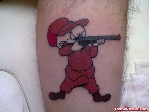 Red Ink Cartoon With Gun Tattoo On Leg