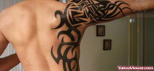 Black Tribal Tattoo On Side and Right Half Sleeve Tattoo