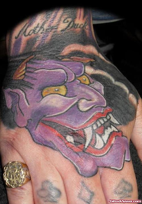 Purple Ink Demon Head Tattoo On Hand