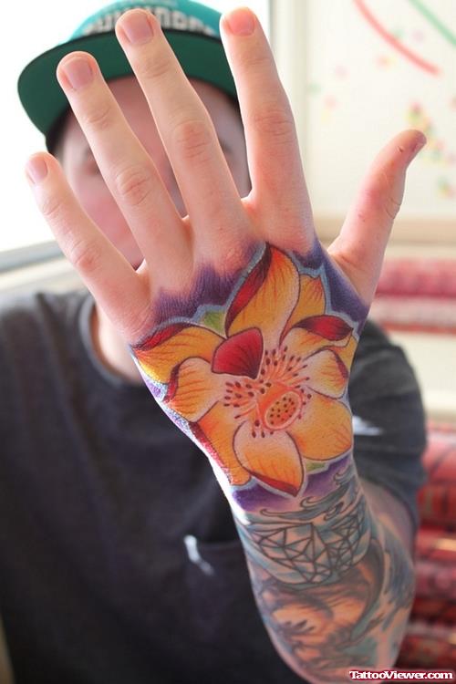 Colored Flower Tattoo On Guy Left Hand