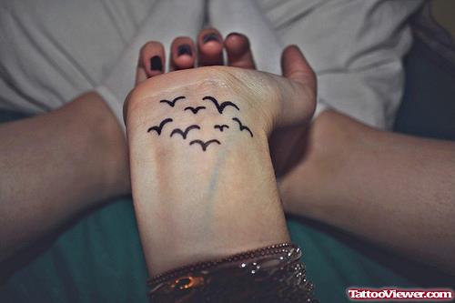 Attractive Black Ink Flying Birds Hand Tattoo