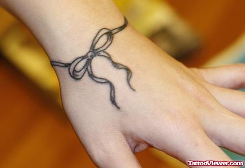 Grey Ink Bow Hand Tattoo
