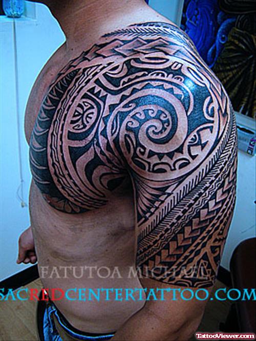 Amazing Black Ink Hawaiian Tattoo On Man Chest And Half Sleeve
