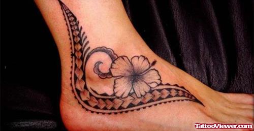 Grey Ink Tribal And Hawaiian Flower Tattoo On Foot