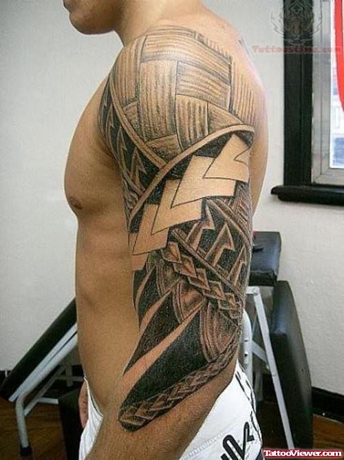 Grey Ink Hawaiian Tattoo On Man Left Sleeve