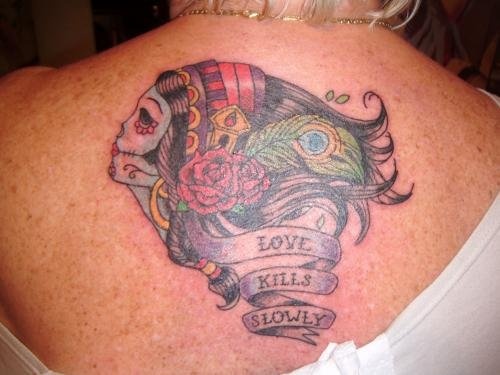 Love Kills Slowly Banner And Head Tattoo On Upperback