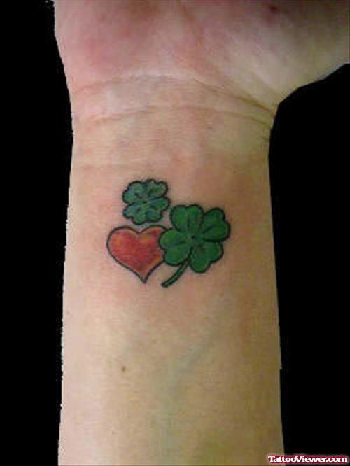 Green Ink clover Leaf And Heart Tattoo On Wrist