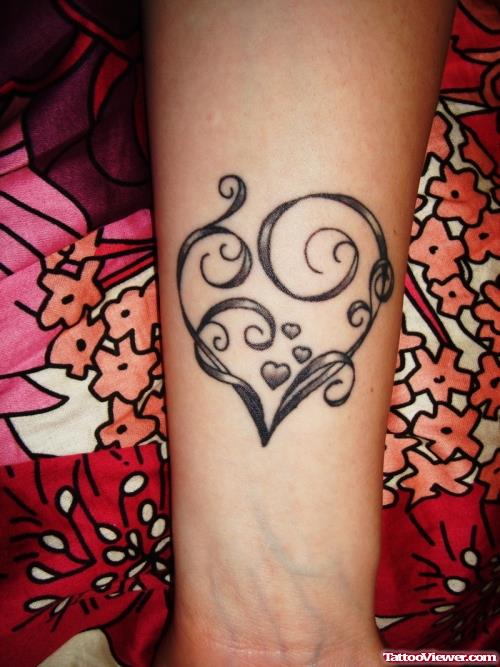 Black Ink Heart Tattoo On Left Arm