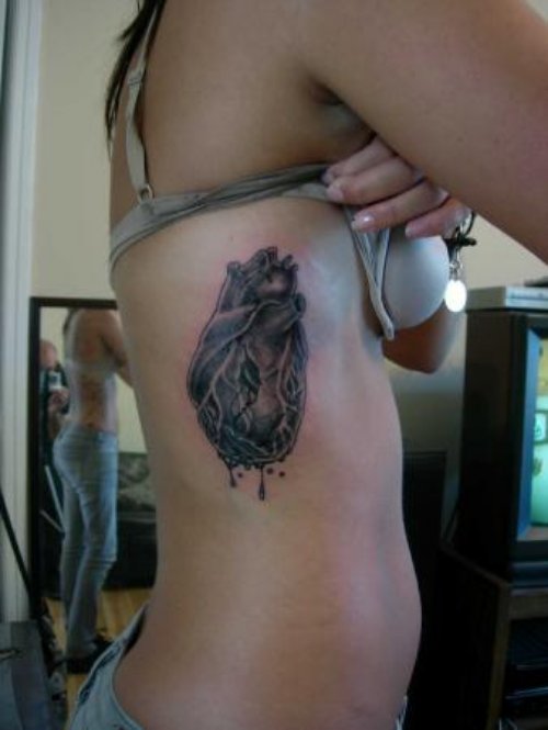 Grey Ink Human Heart Tattoo On Side Rib