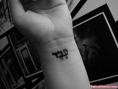 Awesome Black Ink Hebrew Tattoo On Left Wrist