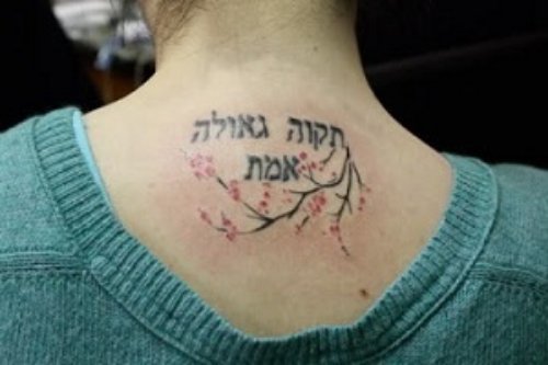 Black Ink Hebrew Tattoo On Girl Upperback