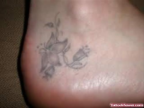 Grey Ink Flower Heel Tattoo For Girls