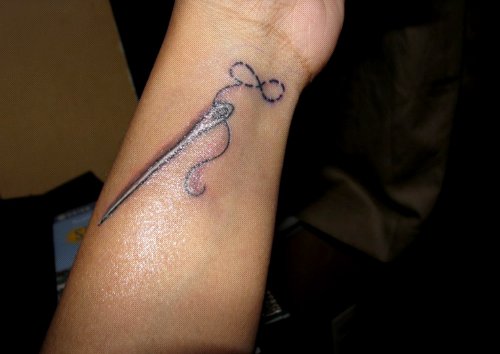 Grey Ink Needle With Thread Infinity Tattoo On Left Forearm