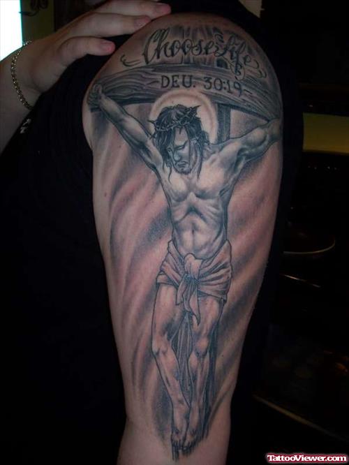 Grey Ink Jesus On Cross Tattoo On Left Sleeve