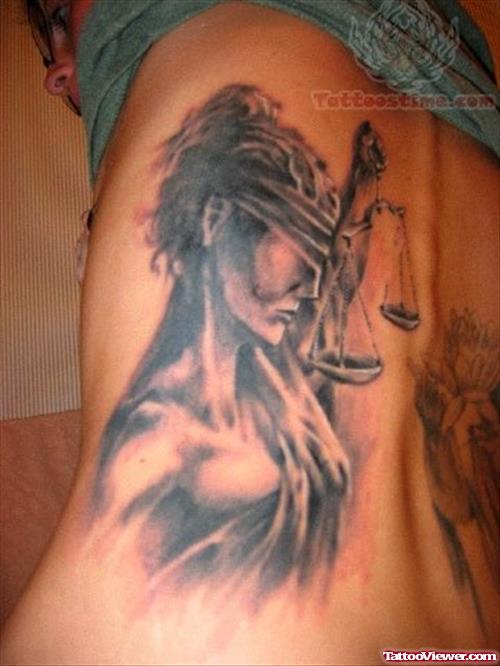 Grey Ink Justice Tattoo On Girl Side Rib