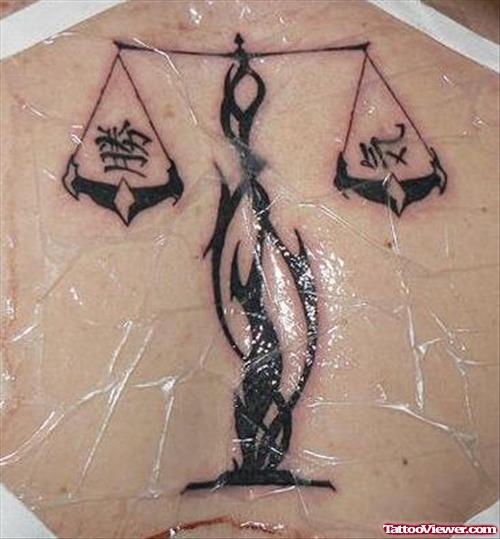 Black Ink Tribal Balance Justice Tattoo On Back