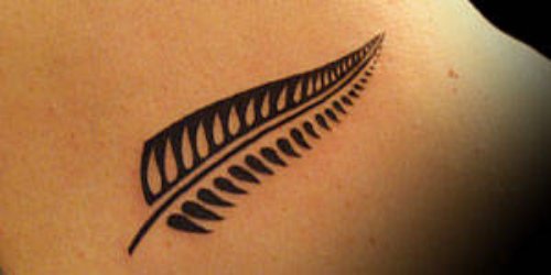Black Fem Leaf Tattoo On Back Shoulder