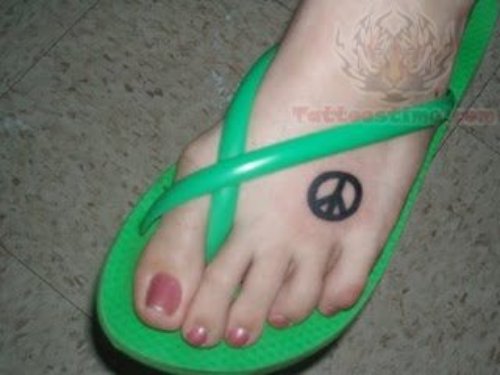 Black Ink Peace Sign Tattoo On Left Foot