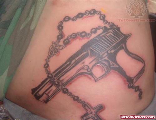 Rosary And Gun Tattoo On Hip