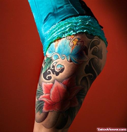 Blue And Red Flower Tattoos On Left Thigh