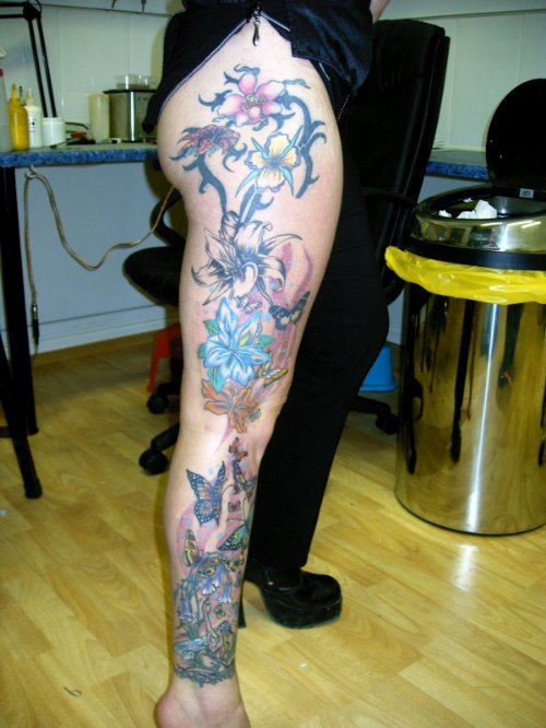 Colored Flowers Tattoos On Thigh and Leg