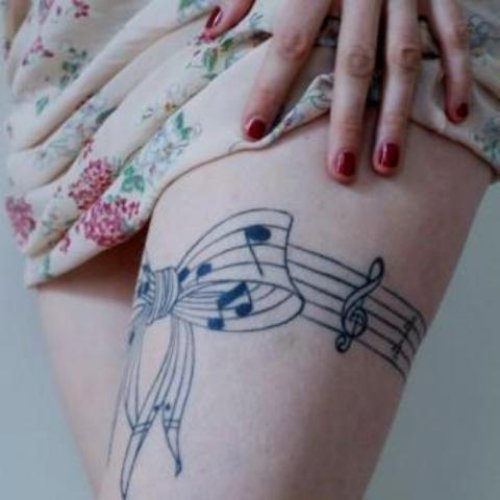 Music Notes Bow Tattoo On Thigh