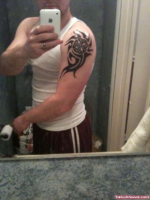 Tribal Black Ink Tattoo On Man Left Shoulder