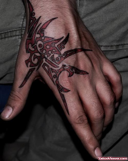 Red Ink Tribal Tattoo On Left Hand