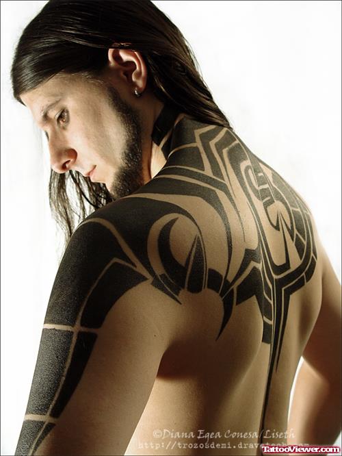 Black Ink Tribal Tattoo On Man Upperback