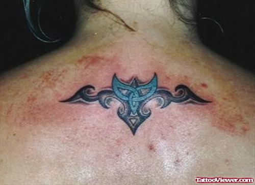 Black And Blue Ink Tribal Tattoo On Upperback